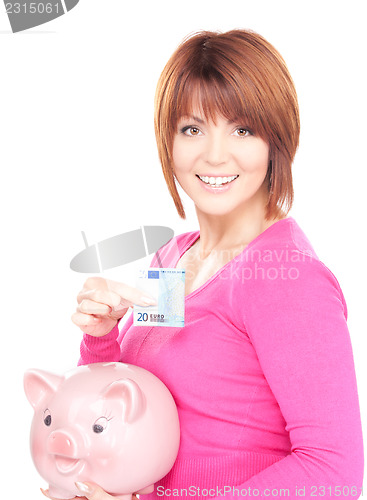 Image of lovely woman with piggy bank and money