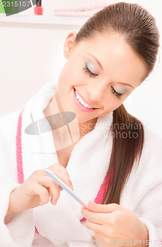 Image of woman polishing her nails