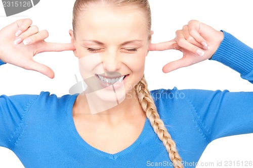 Image of smiling woman with fingers in ears