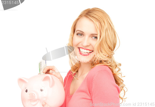 Image of lovely woman with piggy bank and money