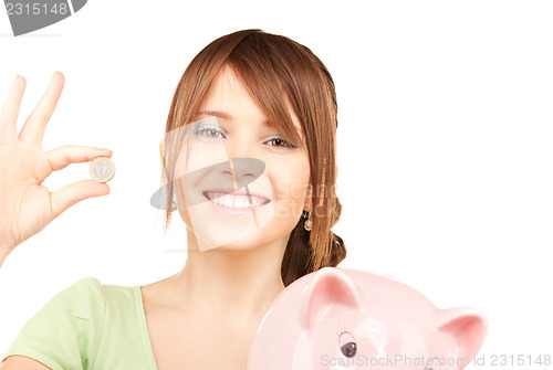 Image of lovely teenage girl with piggy bank and coin