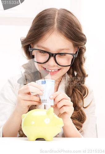 Image of little girl with piggy bank and money