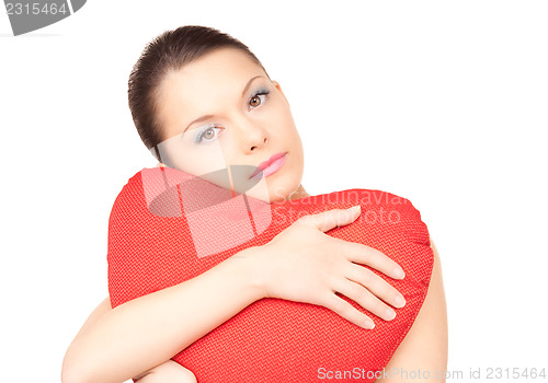 Image of woman with red heart-shaped pillow over white