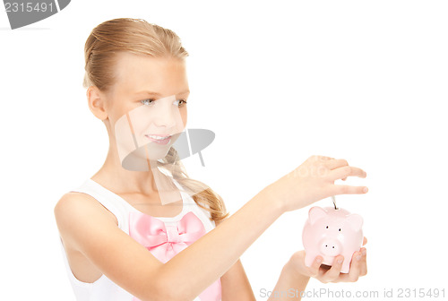 Image of lovely teenage girl with piggy bank and money