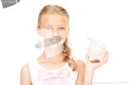 Image of lovely teenage girl with piggy bank and money