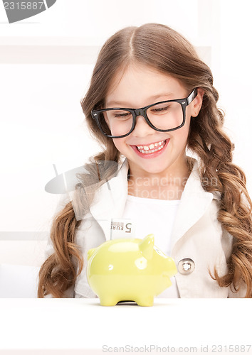 Image of little girl with piggy bank and money