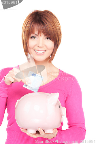 Image of lovely woman with piggy bank and money