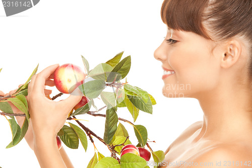 Image of happy woman with apple twig