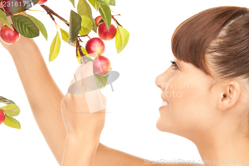 Image of happy woman with apple twig