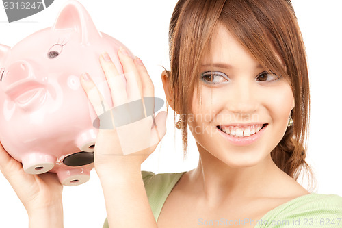 Image of lovely teenage girl with piggy bank
