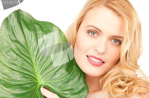 Image of woman with green leaf over white