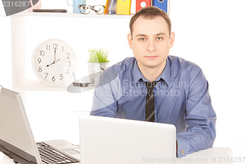 Image of businessman with laptop computer in office