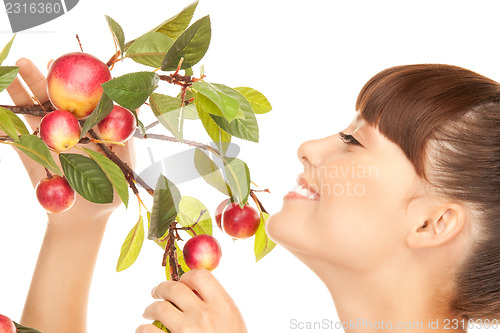 Image of happy woman with apple twig