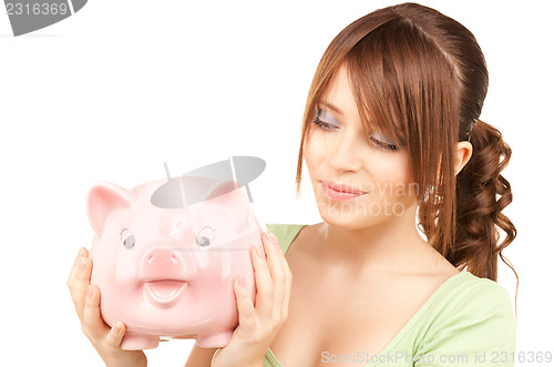 Image of lovely teenage girl with piggy bank