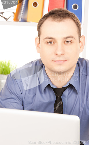 Image of businessman with laptop computer in office