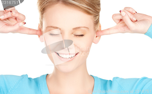 Image of smiling woman with hands over ears