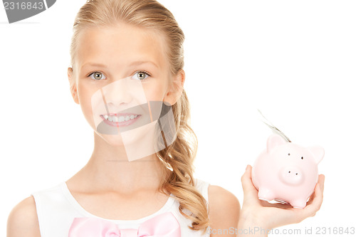 Image of lovely teenage girl with piggy bank and money