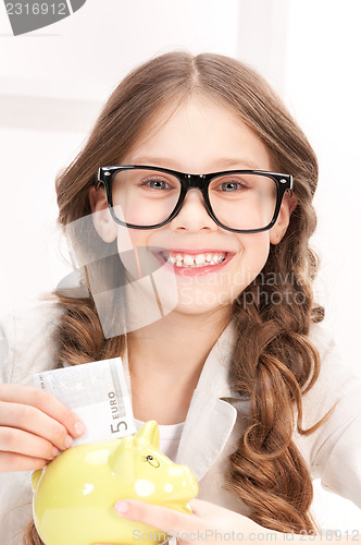 Image of little girl with piggy bank and money