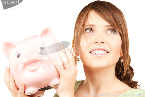 Image of lovely teenage girl with piggy bank