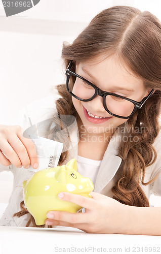Image of little girl with piggy bank and money
