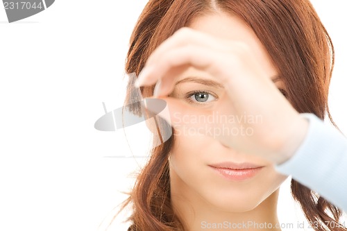 Image of lovely woman looking through hole from fingers