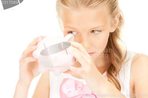 Image of lovely teenage girl with piggy bank