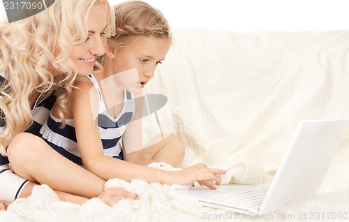 Image of happy mother and child with laptop computer