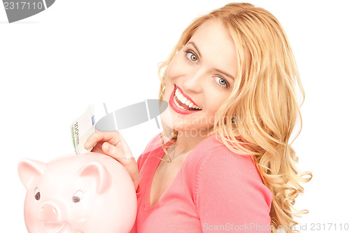 Image of lovely woman with piggy bank and money