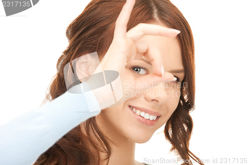 Image of lovely woman looking through hole from fingers