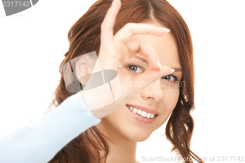 Image of lovely woman looking through hole from fingers