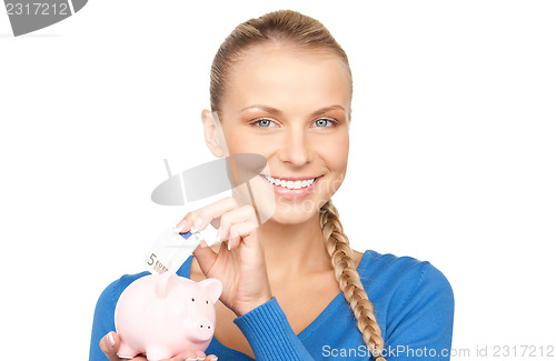 Image of lovely woman with piggy bank and money