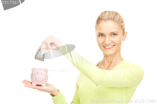 Image of woman with piggy bank and money