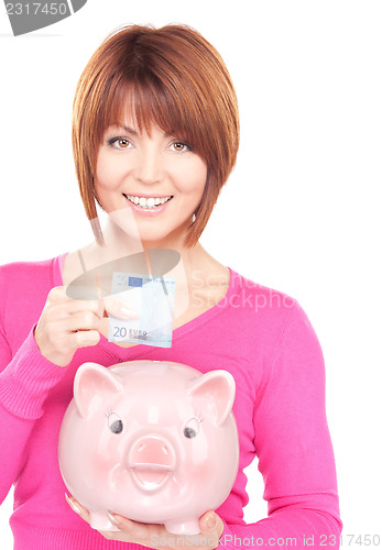 Image of lovely woman with piggy bank and money