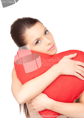 Image of woman with red heart-shaped pillow over white