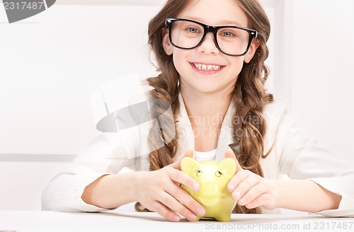 Image of little girl with piggy bank