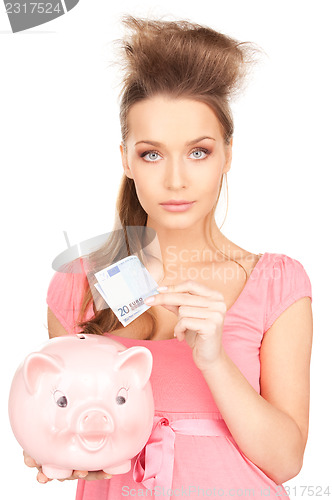 Image of lovely woman with piggy bank and money