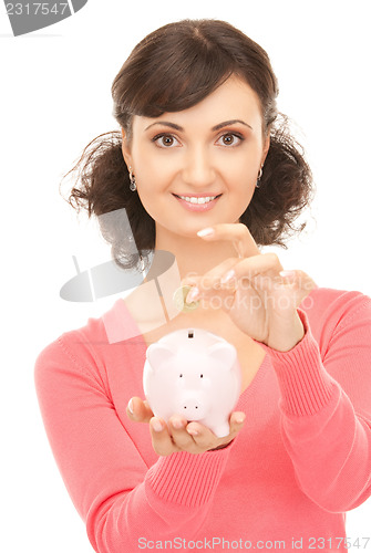 Image of lovely woman with piggy bank and money