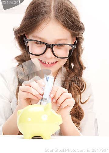 Image of little girl with piggy bank and money