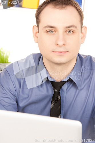 Image of businessman with laptop computer in office