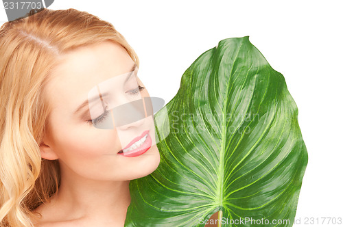 Image of woman with green leaf over white