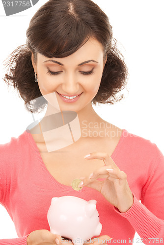 Image of lovely woman with piggy bank and money