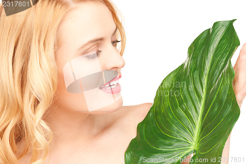 Image of woman with green leaf over white