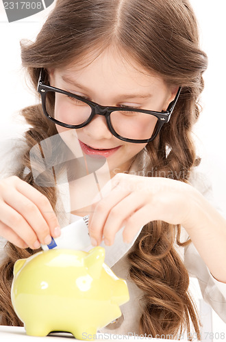 Image of little girl with piggy bank and money