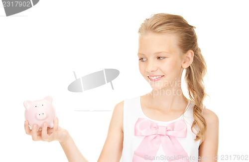 Image of lovely teenage girl with piggy bank