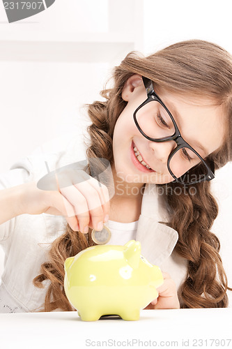 Image of little girl with piggy bank and coin