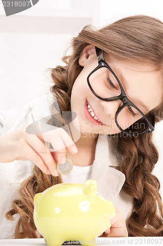 Image of little girl with piggy bank and coin