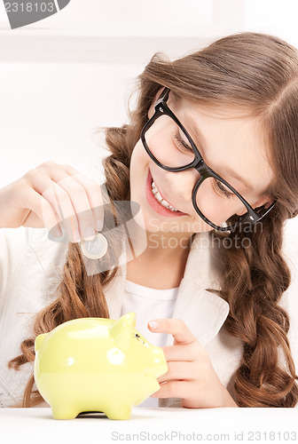 Image of little girl with piggy bank and coin