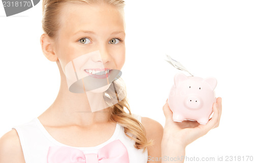 Image of lovely teenage girl with piggy bank and money