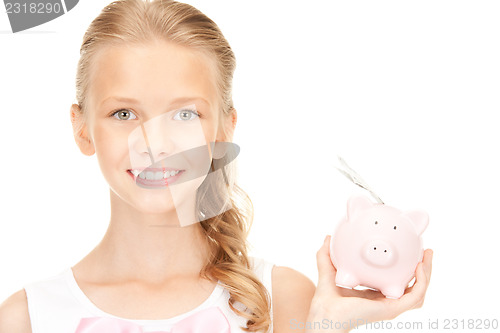 Image of lovely teenage girl with piggy bank and money