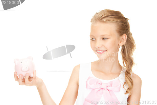 Image of lovely teenage girl with piggy bank